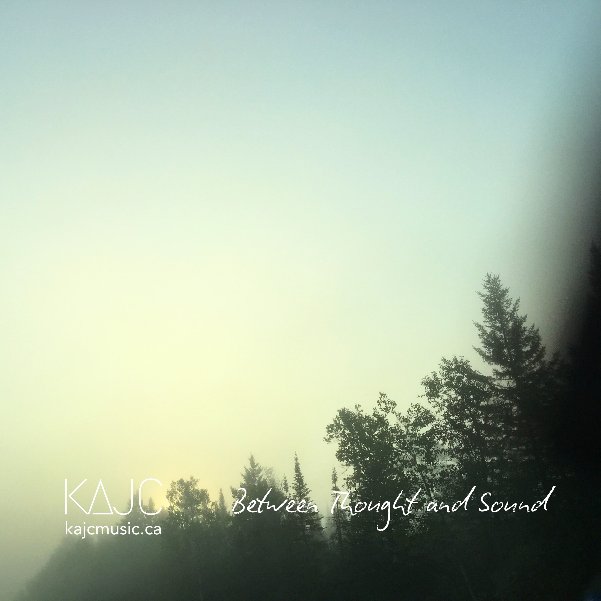 Misty sunrise over a forest of evergreen trees, ambient album artwork for Between Thought and Sound by KAJC Music, evoking reflection, presence, and emotional stillness.